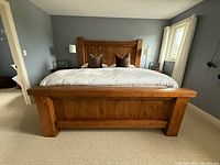 Front view of king bed frame with headboard, footboard, and two end tables