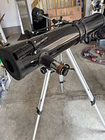 Optical tube on tripod from front angle showing focuser and eyepiece holder