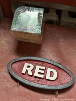 Stack of square Heineken beer coasters sealed in shrink wrap, with red oval sign below