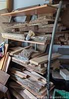 Full view of several shelves filled with thick live edge hardwood slabs and chunks with bark edges, ranging in size and shape.