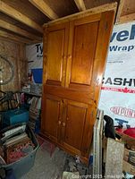 Full front view of the large pine wardrobe showing top and bottom paired cabinet doors in a natural finish.