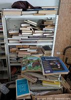 Full metal shelf with stacked books showing assorted sizes and conditions, including books lying flat and upright.