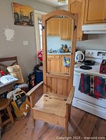 Photo of pine hall tree with visible scratches on the bench seat and mirror reflecting kitchen area