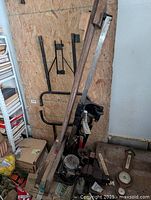 Heavy metal wood lathe tool with long metal framework, motor attached, and some other accessory parts surrounding it.