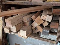 Various hardwood blocks stacked on a shelf showing different sizes and wood types including cherry, oak, maple, and ash for woodturning.