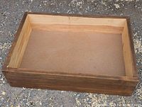 Top-down view of rectangular wooden box showing natural wood interior and darker stained exterior sides.