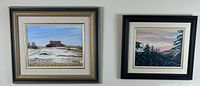 Framed paintings of a farm landscape and a pine tree landscape.