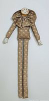 Full body view of the vintage signed Brennan clown doll showing the brown floral patterned outfit and ruffled collar.
