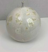 Round crystalline glazed vase showing overall shape, neck, and crystalline spots on glaze.