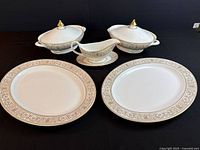 Full view of the Royal Doulton Sovereign set showing two covered serving dishes, two platters, and a gravy boat with saucer on a black background.