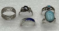 Five sterling silver rings displayed together showing various styles and stones.