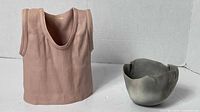 Pink T-shirt shaped vase and grey pottery bowl, front view