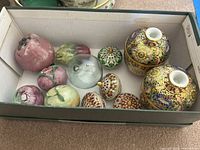 Photo of boxed lot showing two decorated Chinese porcelain vases, six ceramic decorative fruit figures, including pomegranate shapes and a glass dome.