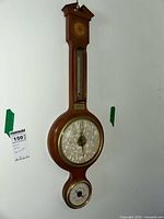 Full view of the vintage wooden wall-mounted weather station showing thermometer at top, large circular barometer in middle, and smaller circular hygrometer at bottom.