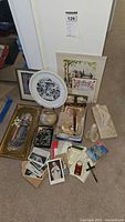 Photo showing entire collection including framed pictures, religious plate, rosary beads, crucifix, and various small religious items on carpeted floor
