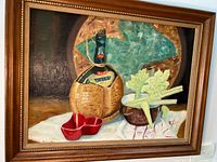 Frontal photo of the signed oil painting showing the still life scene and wooden frame.