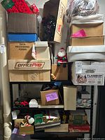 Wide view shelving with stacked boxes and visible holiday decor included Santa figurines and wreaths.