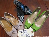 Three pairs of women's designer dress shoes displayed on a wooden table: green open toe low heel shoes by Rebeca Sanver, light pink open toe low heel shoes by Lian, and black and white polka dot closed toe heels by Fedorio Rusconi by Pegaso.