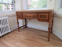 Front and left three-quarter view of the console table by a window