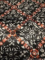 Full view of folded scarf showing geometric and logo pattern