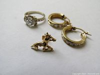 Ring, hoop earrings and tie tack pin arranged on white background