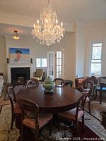 Wide shot of the large round Mahogany dining table with chairs around it, showing its placement in a room and the flamed wood grain top.