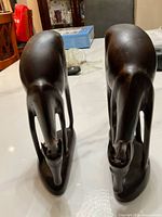 Two handcrafted wooden gazelle sculptures shown from the top front angle, highlighting the carved head and neck detail.