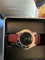 Front view of Swiss Military unisex wristwatch with black dial, silver-tone bezel with Roman numerals, and brown leather strap inside protective box.