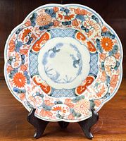 Front view of the antique Imari porcelain plate showing the full design and scalloped edge.