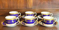 Six Coalport Lady Anne cups and saucers arranged in two rows on wooden surface