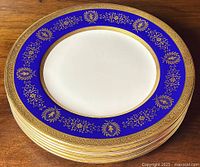 Stack of six dinner plates showing cobalt and gold border.