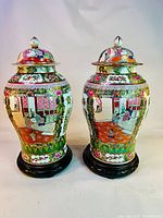 Front view of both jars with lids on wood display stands