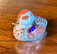 Front angle view of Royal Crown Derby swimming duckling paperweight showing detailed pattern and gold stopper.