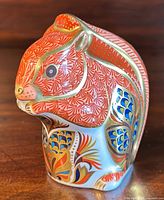 Front three-quarter view of red squirrel paperweight showing overall shape and decoration