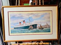Full front view of the framed print showing Queen Elizabeth ocean liner with tugboats in port and the entire frame.