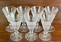 Seven Waterford Tramore crystal sherry glasses arranged on wood surface, view from front