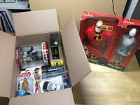 Two large boxed Incredibles 2 collectible figures, Mr. Incredible and Frozone, next to the open box.