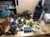 Overall collection of figurines, lamps, Buddha statue, and decorative items arranged on a table.