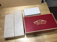 Four boxes on table including a Vans shoe box and white and cardboard boxes, presumably holding the cards.