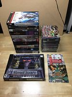 PC game collection laid out on table with three main stacks, showing range of titles and conditions.