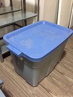 Large gray plastic storage tote with blue lid closed