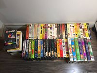 Photo showing an assortment of VHS tapes laid out including Disney movies, mixed genre movies, and BASF T-120 blank tape boxes.