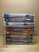 Stack of 10 VHS tapes side view showing titles and sealed plastic sheeting.