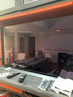 Front view of 49-inch LG OLED TV on stand with accessories laid out on tabletop