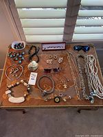 Overview of sunglasses and jewelry on tabletop