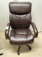 Front view of brown La-Z-Boy office chair showing padded seat, backrest, headrest, armrests, and caster wheels.