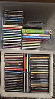 Two bins filled with rows of music CDs featuring various artists and genres, cases and booklets visible.