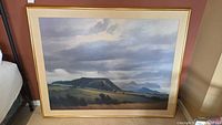 Full view of framed landscape painting showing gold wood frame and canvas scene.