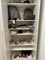 Full view of shelving unit with backpacks, bags, accessories, shapewear and shoe care items displayed