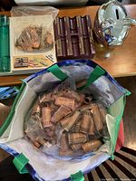 Full view of the Coinmaster coin roller, rolls of pennies in bag, loose pennies in bags, and ceramic piggy bank on table.